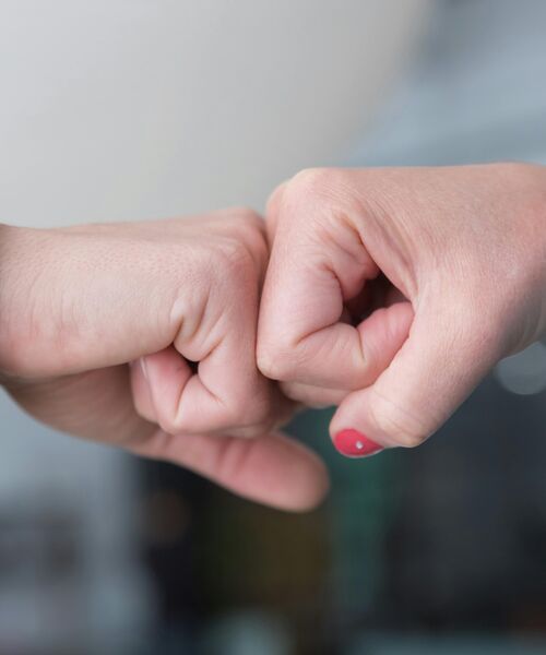 Zwei Fäuste stoßen zur Begrüßung oder Bestärkung aneinander.